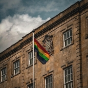 A rainbow pride flag flies on a pole in front of the Town Hall