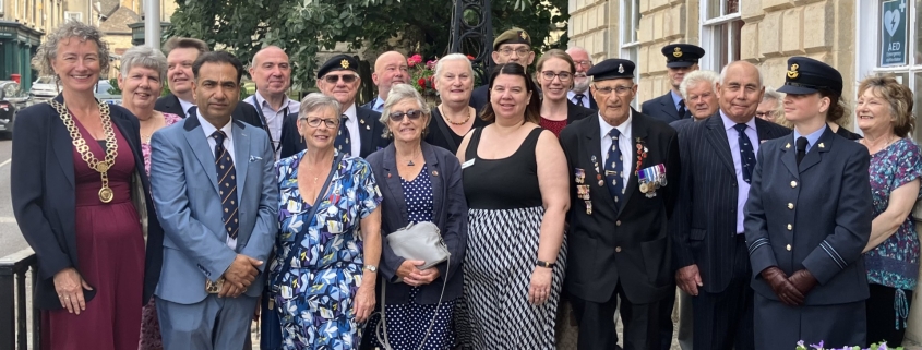 A group of people gather for the short flag raising ceremony.