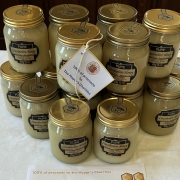 A display honey on a table, with a small flag stating proceeds go to the Mayor's Charities.