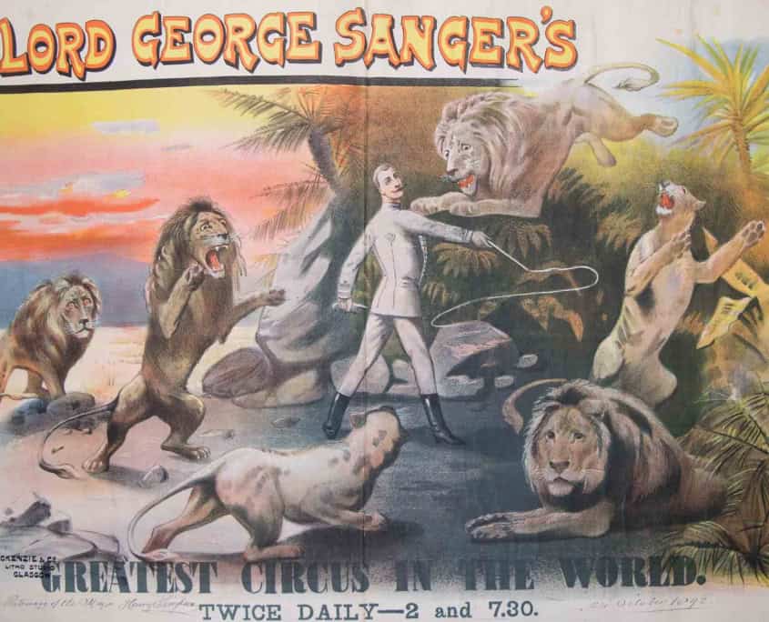 A vintage circus poster shows a man with a whip surrounded by lions and a tiger, promoting "Lord George Sanger's Greatest Circus in the World.